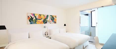 Habitación de hotel con dos camas, un escritorio y un cuadro abstracto colorido en la pared.
