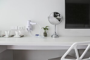 A white desk with a hairdryer, a small mirror, and a potted plant. - CityInn Hotel Plus Ximending Branch (Taipei)