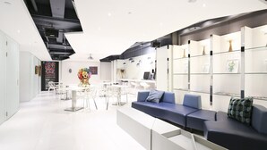 A modern interior with white furniture, a blue sofa, and glass display shelves.