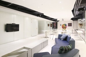 A modern interior with a white reception desk, seating area, and artwork on the walls. - CityInn Hotel Plus Ximending Branch (Taipei)