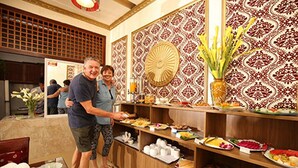 A buffet area with a variety of food items and a decorative wall with a fan. - Aquarius Grand Hotel (Hanoi)