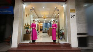 A hotel entrance with a reception desk, a chandelier, and a sign indicating room number 90B. - Aquarius Grand Hotel (Hanoi)