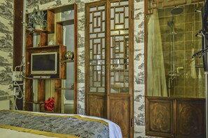 A bedroom with a bed, a television, a wooden wardrobe, and a shower area. - Hill Lily Courtyard (Beijing)