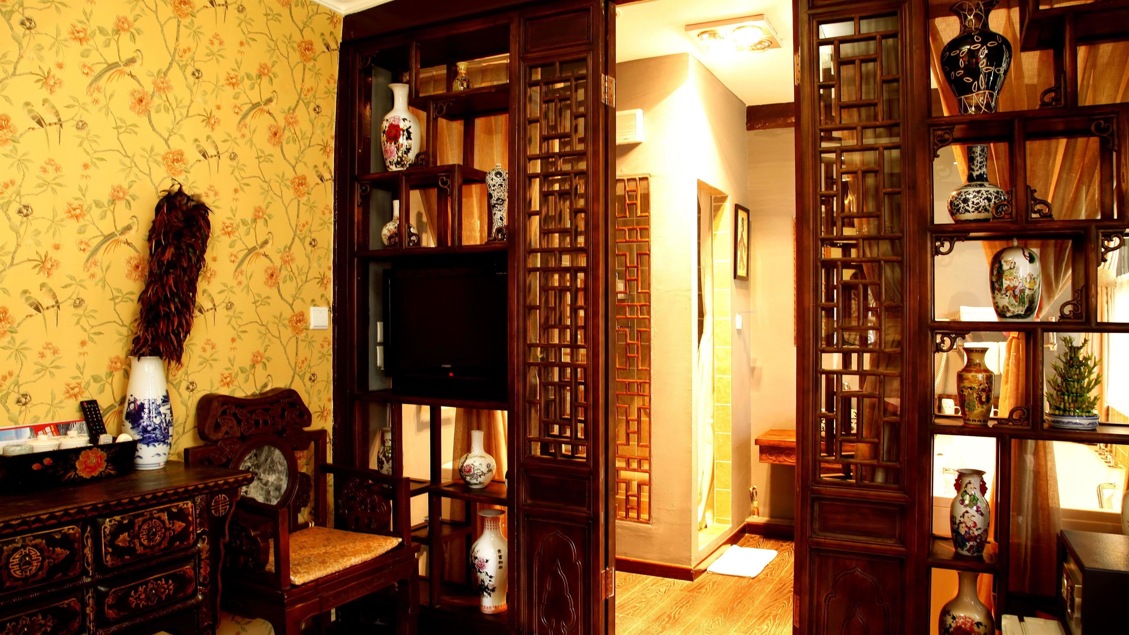 A traditional room with a wooden cabinet, a television, and a decorative screen door.