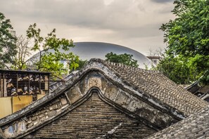 A traditional roof with a steep, tiled design, likely part of an older building. - Hill Lily Courtyard (Beijing)