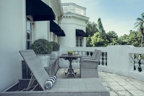 A balcony with wicker furniture, a table, and potted plants. - Paradise Road Tintagel Colombo (Colombo)