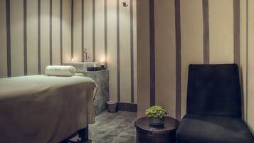 Relax in a serene space with a neatly made bed, a stylish chair, and a potted plant.