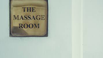 A sign that reads "THE MASSAGE ROOM" on a wall.