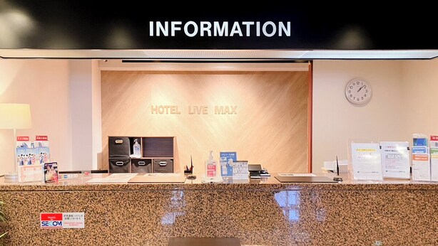 Un mostrador de recepción de hotel con un letrero que dice "HOTEL LIVE MAX".