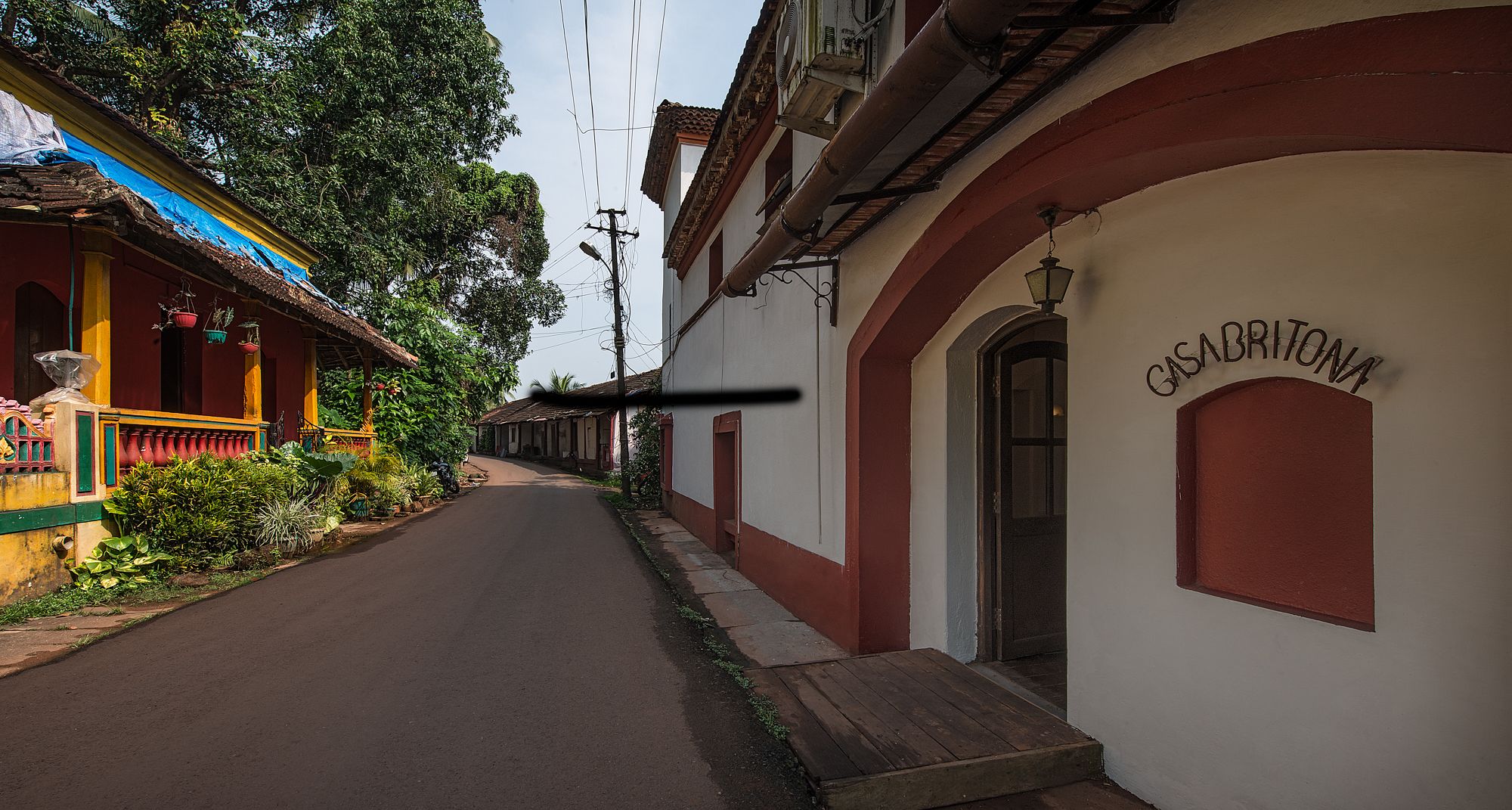 A narrow street lined with buildings, one with a sign reading "CASABRITONA".