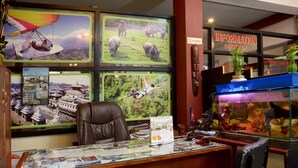 A reception desk with a calendar, a desk lamp, and a fish tank. - Hotel Silver Home - Hostel (Kathmandu)