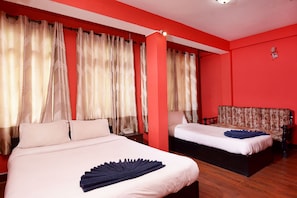 A hotel room with two beds, red walls, and a large window with curtains. - Hotel Silver Home - Hostel (Kathmandu)