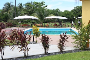 Piscine extérieure, parasols de plage, chaises longues