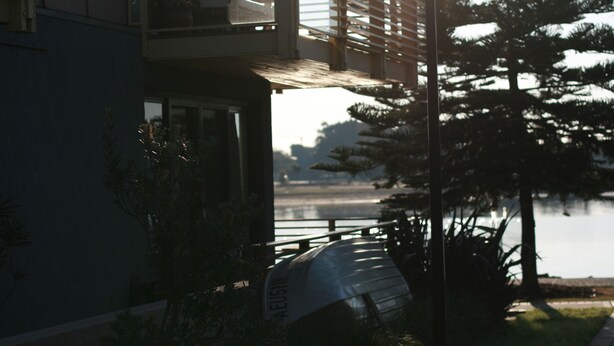 A modern building with a balcony overlooking a body of water. - Harbourside Terraces (Wickham)