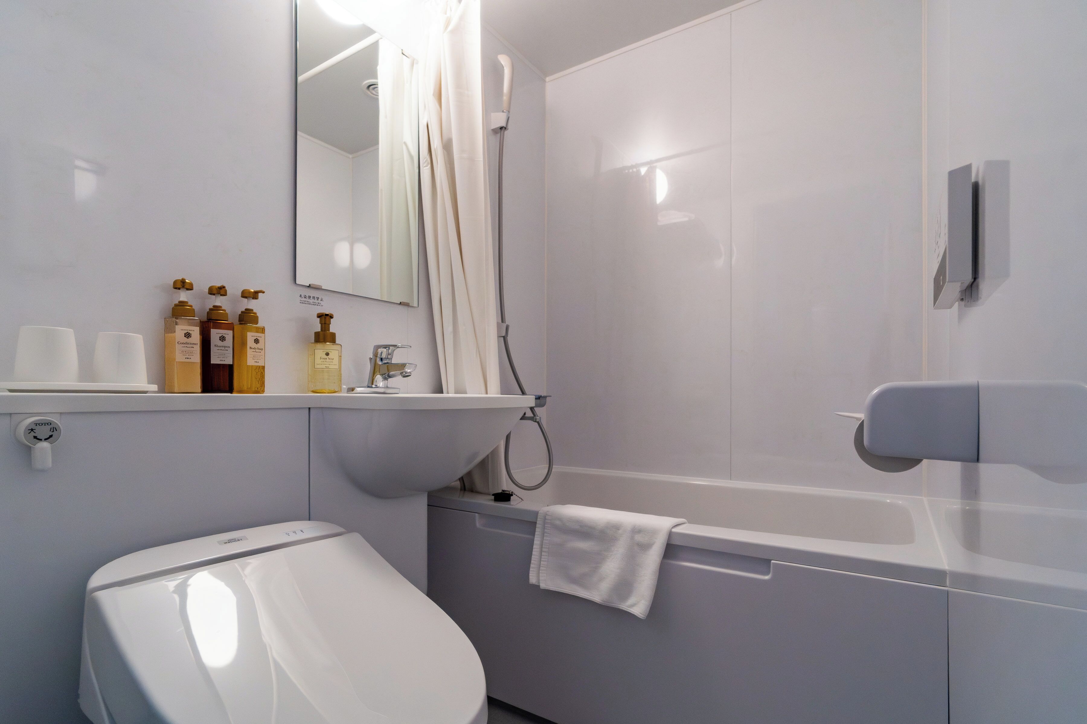 A modern bathroom with a toilet, sink, and shower.