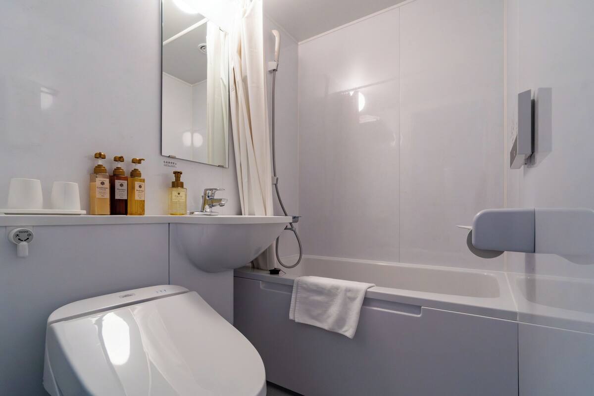 A modern bathroom with a toilet, sink, and shower.
