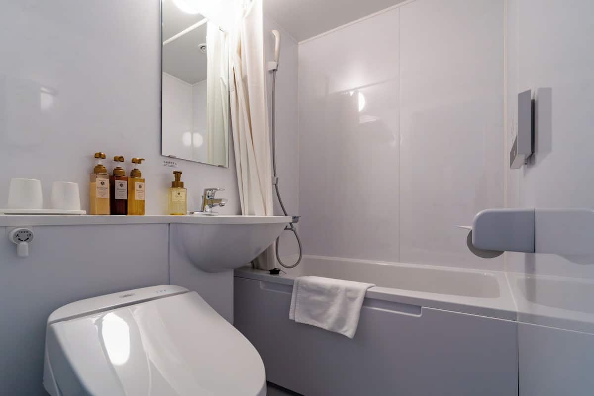 Une salle de bain moderne équipée de toilettes, d’un lavabo et d’une douche.