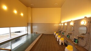 Un long espace piscine étroit, délimité par une paroi en verre, avec plusieurs lavabos équipés de miroirs et des tabourets jaunes.