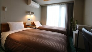 A hotel room with two beds, a desk, a refrigerator, and a potted plant. - Hotel Live Max Yumoto (Iwaki)