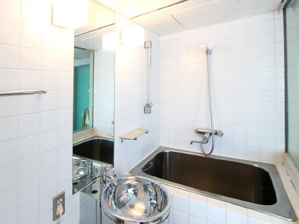 A bathroom with a sink, mirror, and shower.