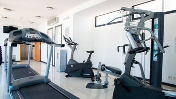 A gym with treadmills, elliptical machines, and weight equipment.