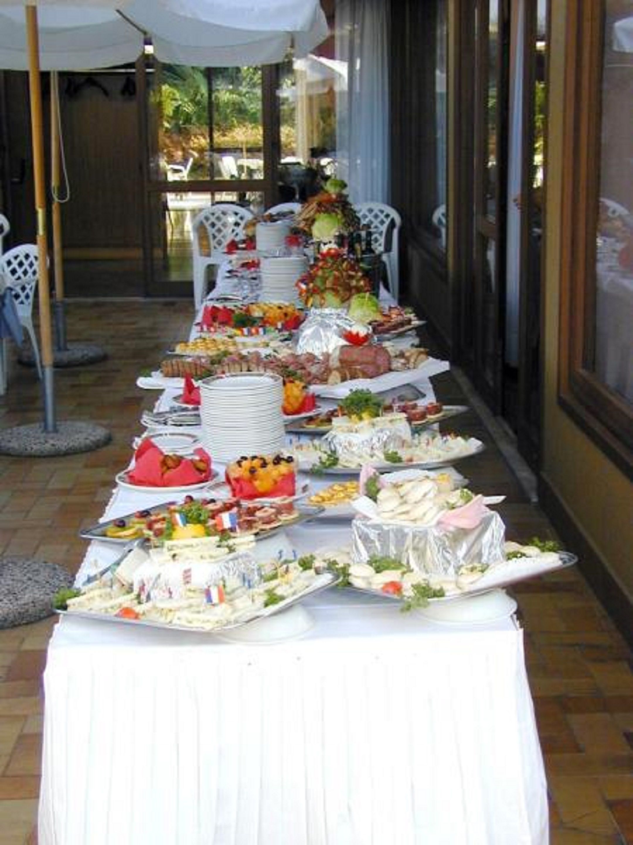 Ein reichhaltiges Buffet mit verschiedenen Speisen und einer weißen Tischdecke.