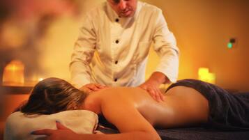 A massage therapy session in a dimly lit room with candles.