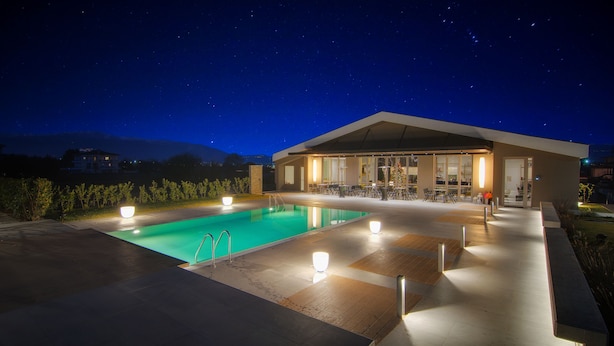 A modern outdoor pool area with a covered seating area and a poolside bar. - Ellopia Point Hotel (Ioannina)