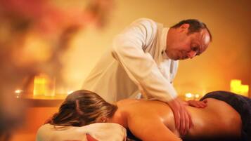 Een massage in een warm verlichte ruimte met kaarsen.