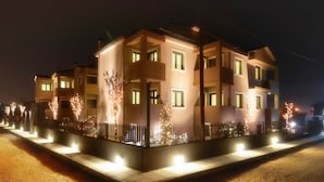 A multi-story residential building with illuminated windows and a well-lit entrance. - Ellopia Point Hotel (Ioannina)