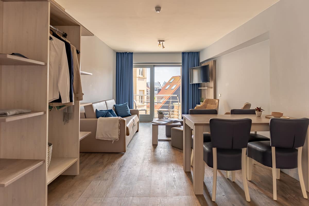 Un apartamento moderno con sala de estar, comedor y un balcón con vistas a la ciudad.