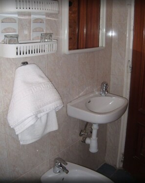 A bathroom with a sink, a mirror, and a towel rack. - Puerta del Sol Rooms (Madrid)