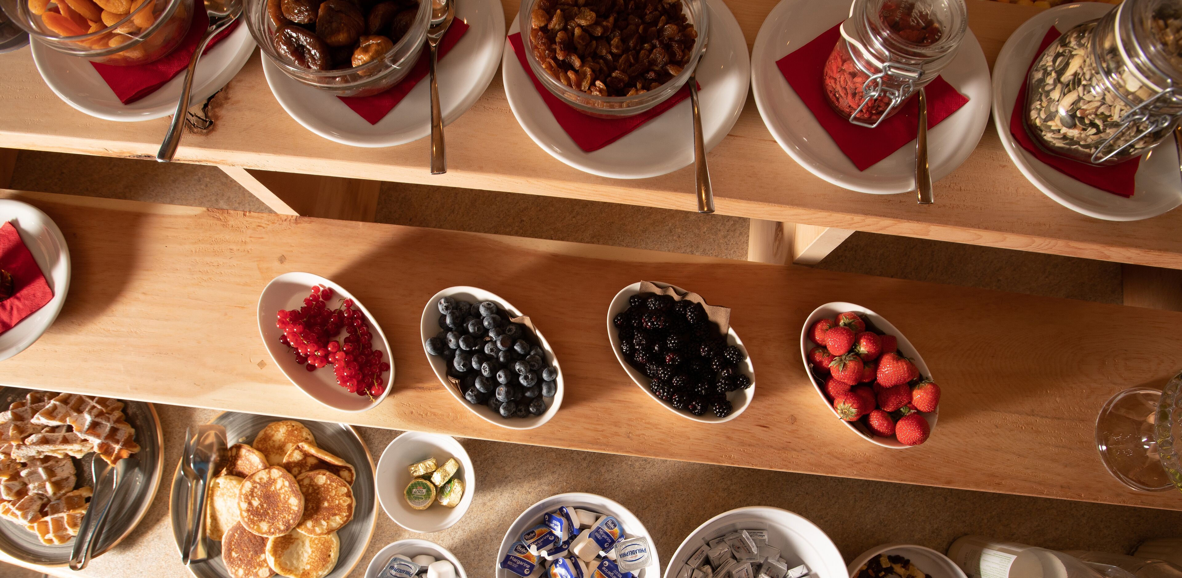 A breakfast buffet with various food items and utensils.