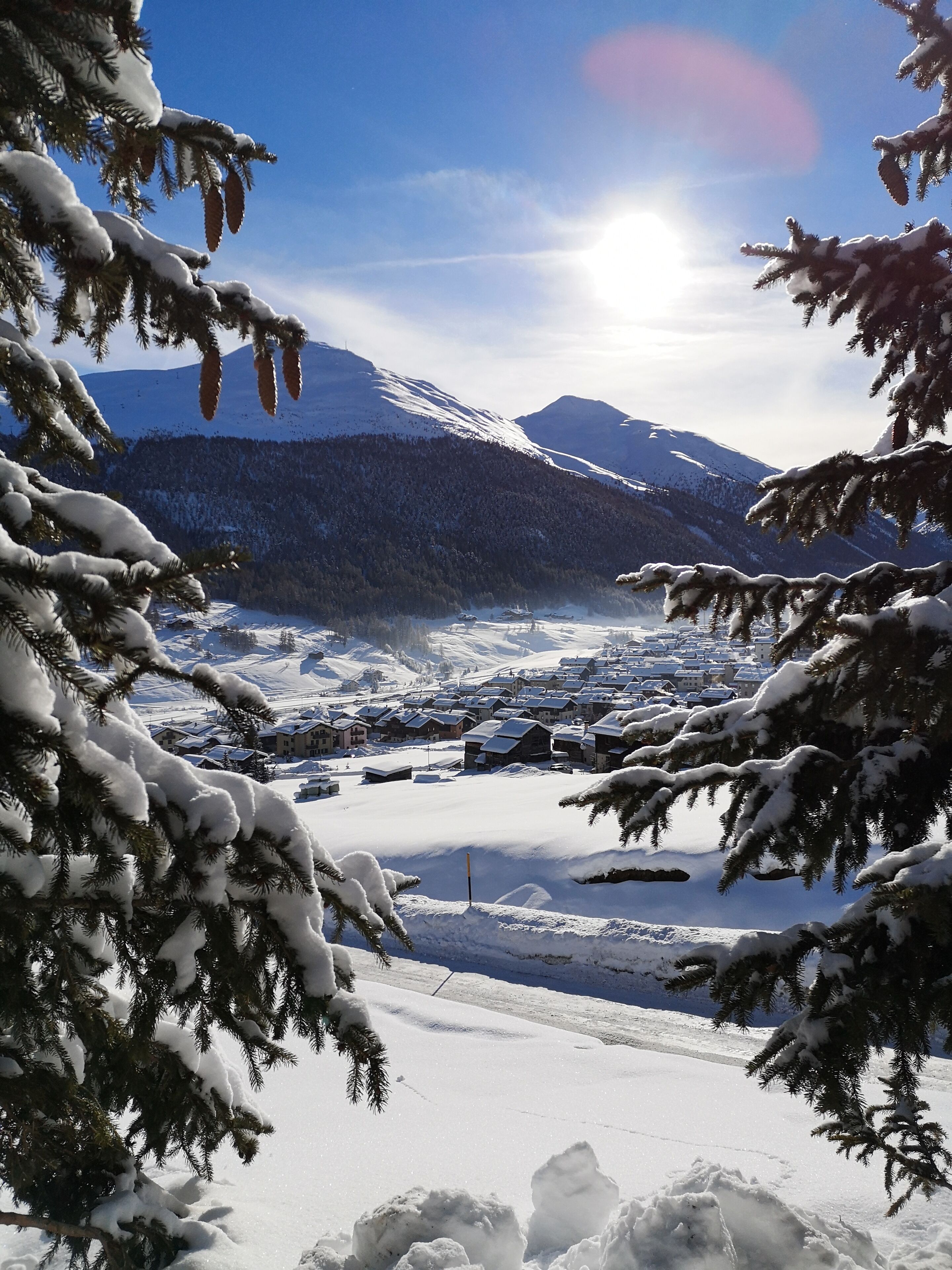 A snow-covered landscape with mountains in the background and a clear sky.