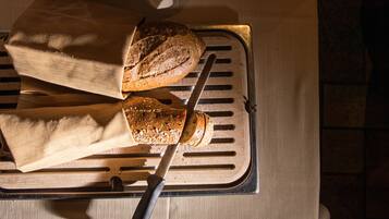 Een brood op een metalen plank met een mes.