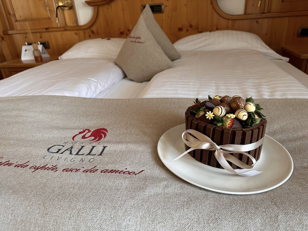 Una cama con un almohadón y un plato con un postre de chocolate.