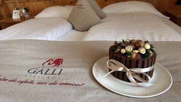 Una cama con un almohadón y un plato con un postre de chocolate.