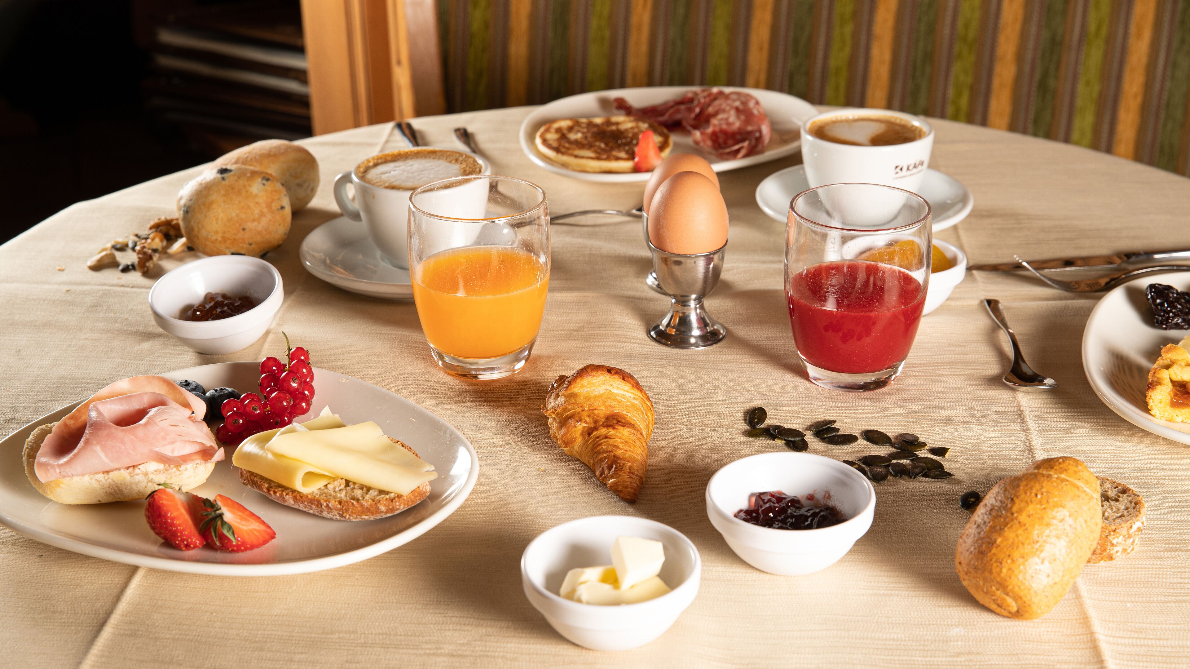 A breakfast setting with various food items and drinks on a table.