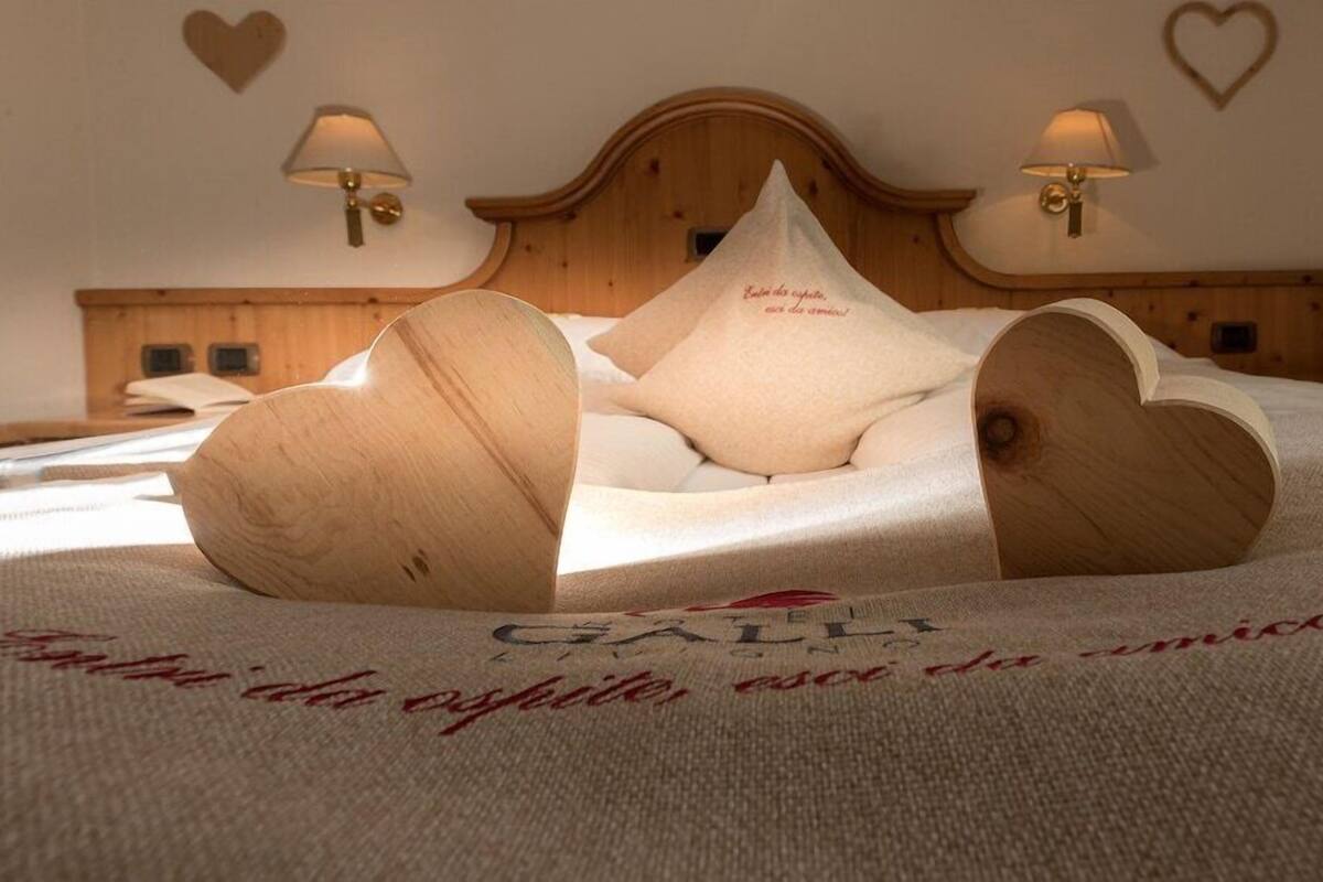 A bed with heart-shaped pillows and a wooden headboard.