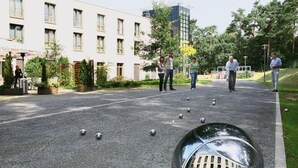 A courtyard with a reflective sphere, a building with multiple windows, and a few people standing around. - Akademiehotel Dresden (Dresden)