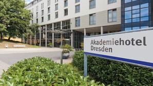 An exterior of a building labeled 'Akademiehotel Dresden' with a modern architectural design, large windows, and a paved entrance area. - Akademiehotel Dresden (Dresden)