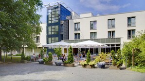 A modern building with outdoor seating and potted plants. - Akademiehotel Dresden (Dresden)