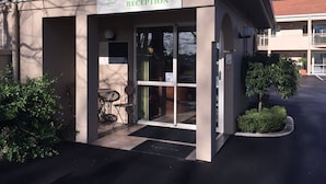 A reception area with a sign reading "Welcome RECEPTION" and a "TUSCANA MOTOR LODGE" sign above it. - Tuscana Motor Lodge (Christchurch)