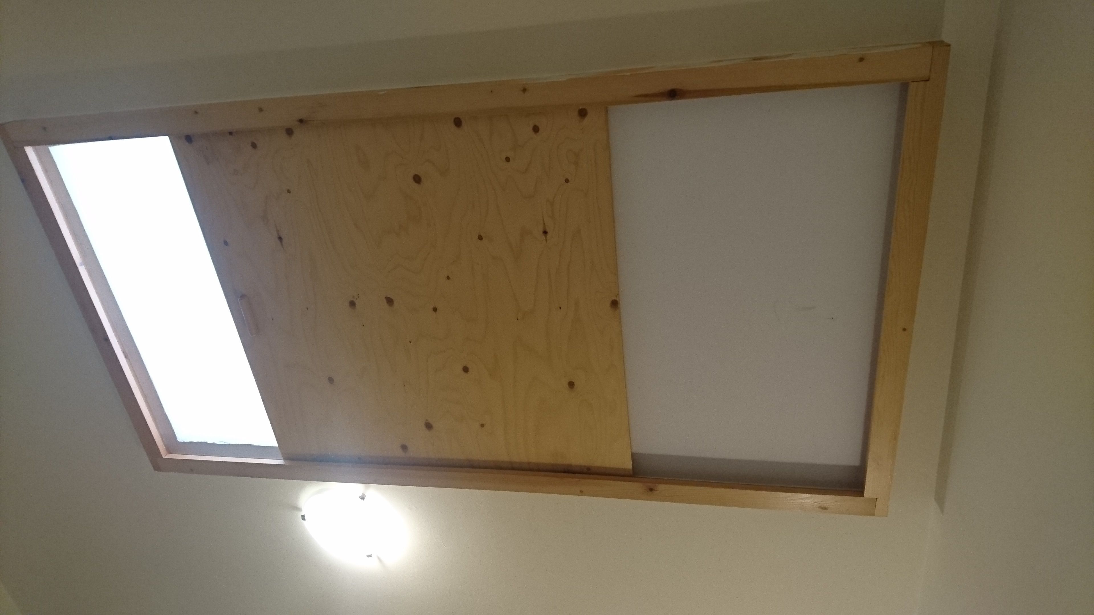 A skylight with a wooden frame and a white ceiling.