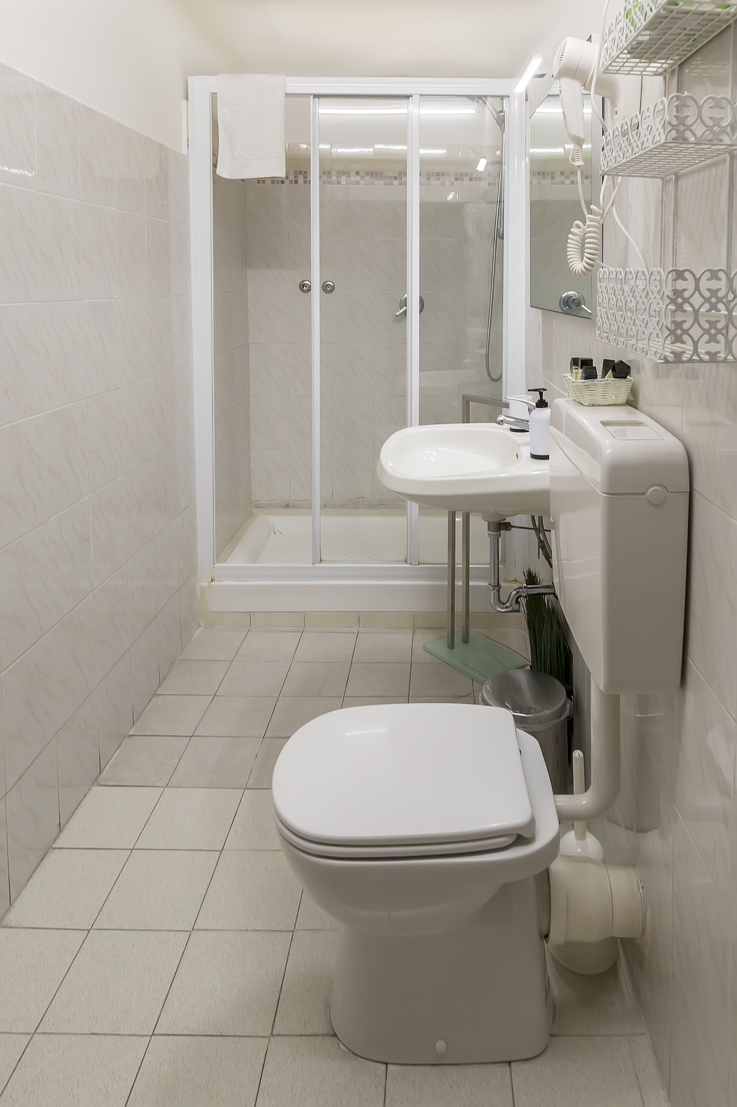 Et moderne badeværelse med toilet, vask og bruseområde.
