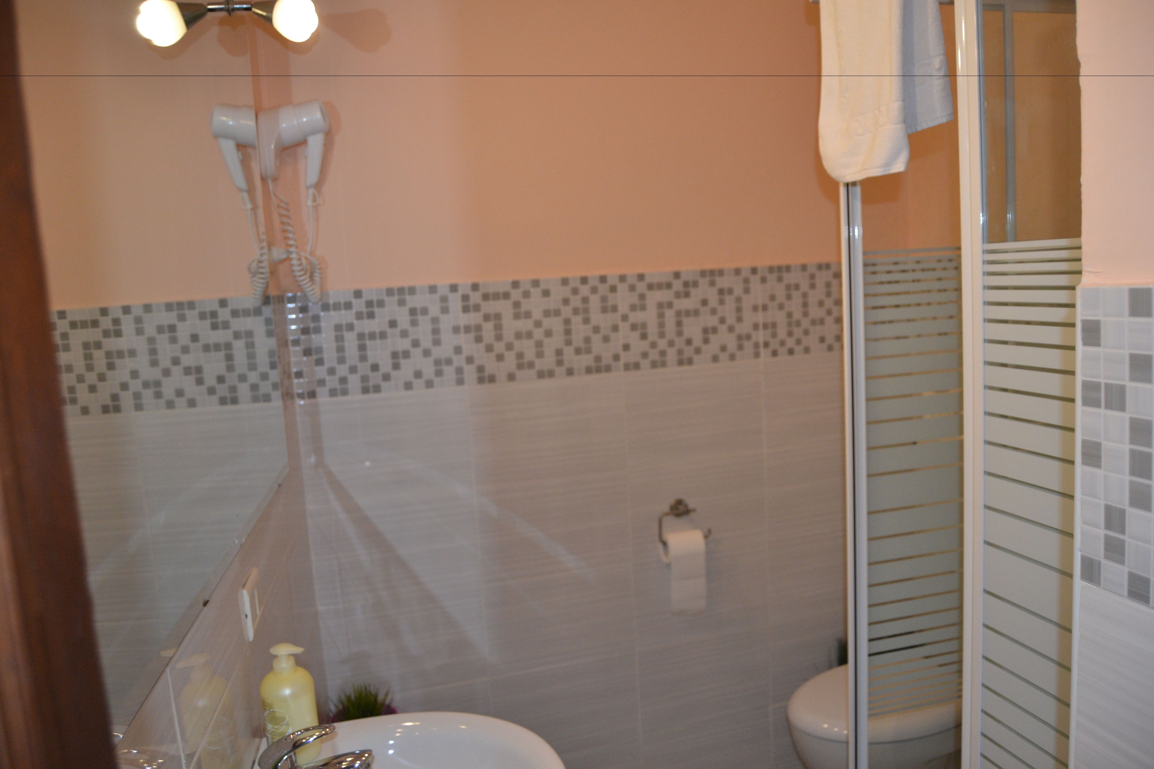 A bathroom with a shower, toilet, and sink.