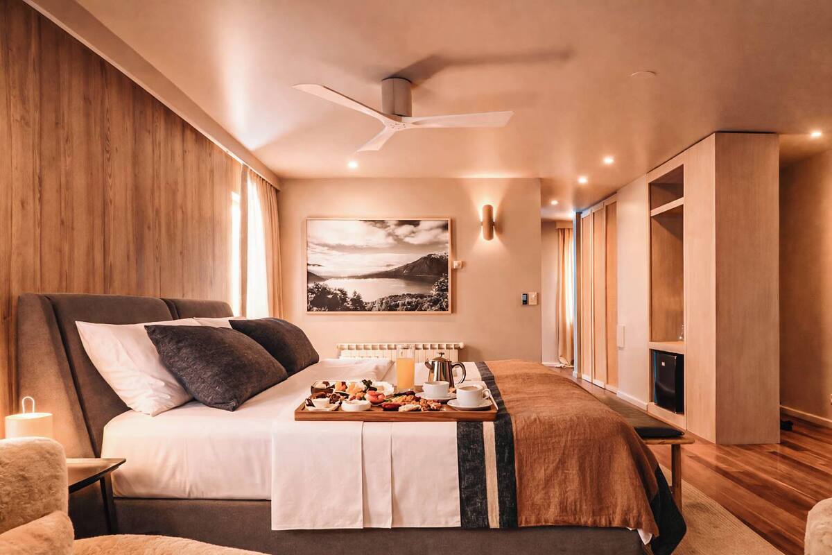Ein modernes Schlafzimmer mit Bett, Nachttisch und Frühstücksbrettchen.