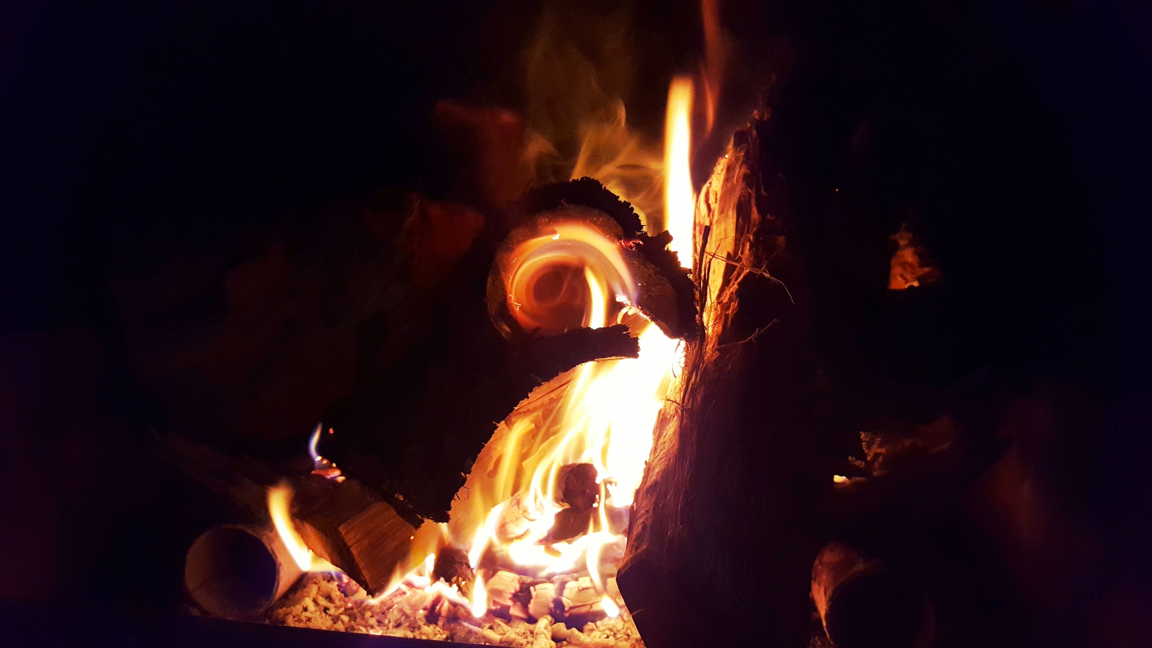 A close-up of a fire with visible flames and logs.