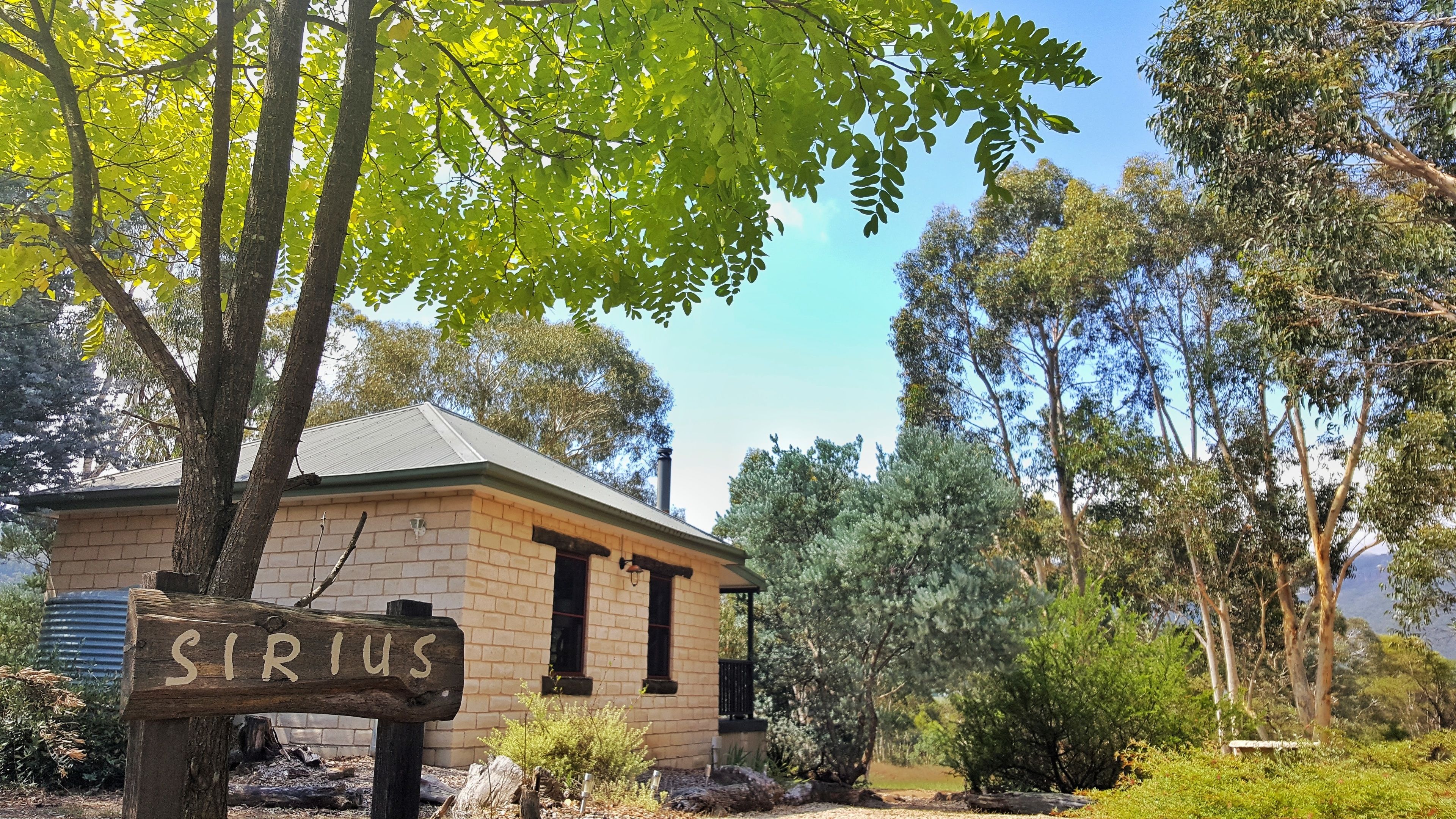 A small stone building with a sign reading "SIRIUS" in front.