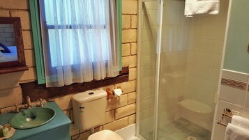 Un baño con lavamanos, inodoro y ducha.